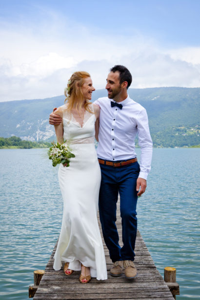 Couple de mariés devant un lac